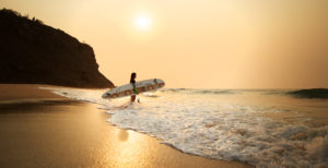 Woman on the beach with surfboard